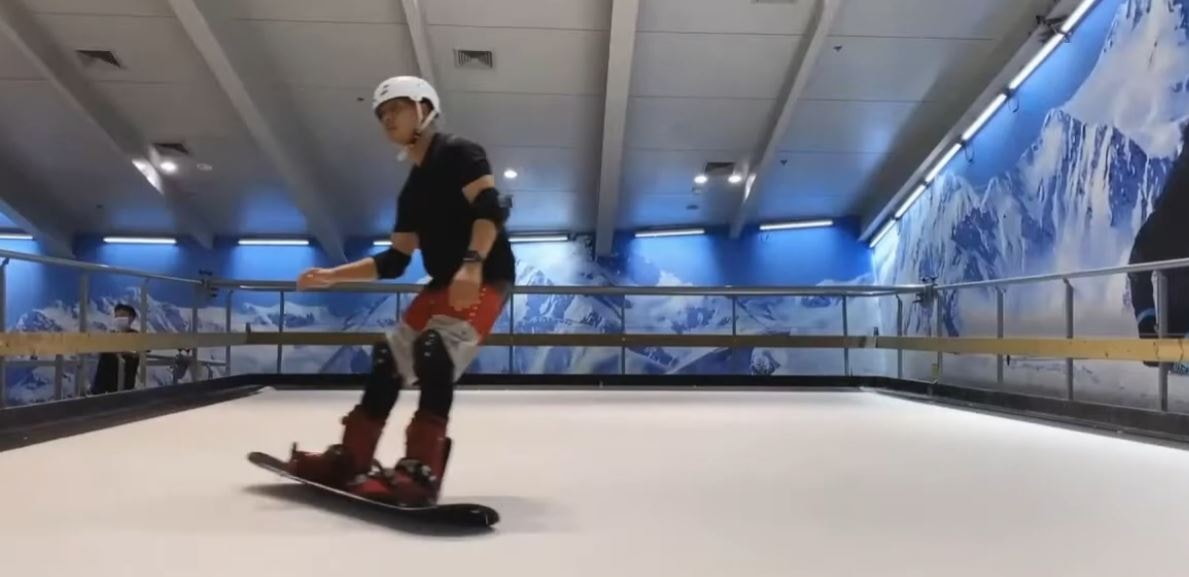 Snowboarder on ski treadmill with mural